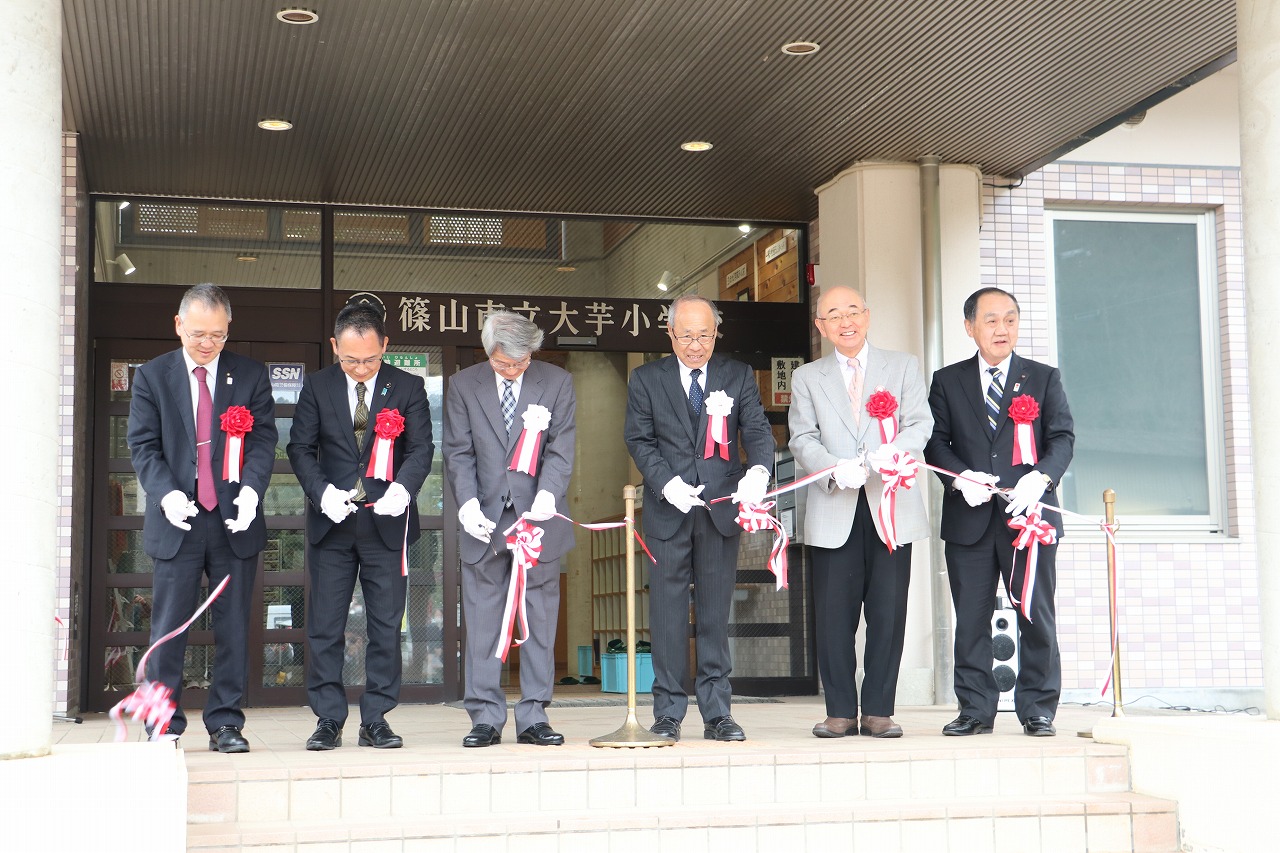 小学校前でテープを切る酒井市長や森本議長など