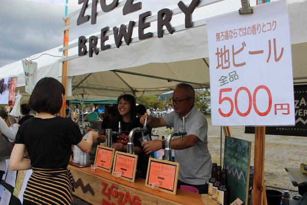 テントの中で販売している地ビールを女性が買いに来ている写真