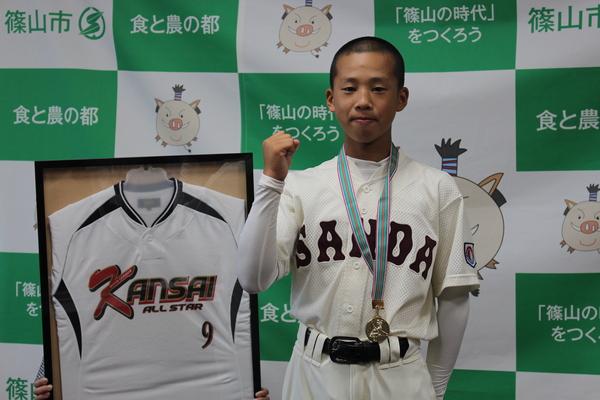 萱野 咲也さんがメダルを首にかけガッツポーズで写っている写真