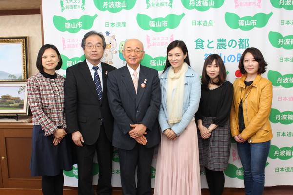 市長と龍媚（LONGMEI）さん、他女性3名と、男性1名が横に並んで記念撮影をしている写真
