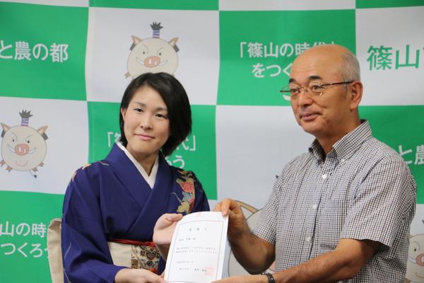 地域おこし協力隊の岸田さんと市長が委託状を一緒に持ってのツーショット写真