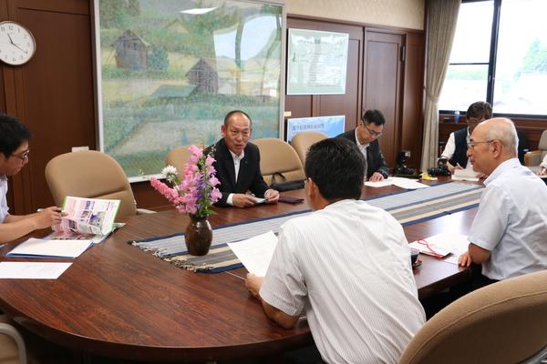フルヤ工業株式会社の代表取締役社長の降矢 寿民さんが話をしている正面に市長が座り話を聞きその周りには関係者の方がが座っている全体を写した写真