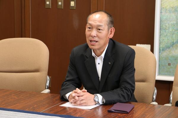 フルヤ工業株式会社の代表取締役社長の降矢 寿民さんが、応接室で着席している写真