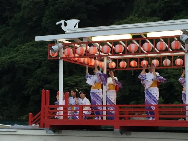 ちょうちんが飾られた舞台で、浴衣を着た女性が踊ったり、手を振っている写真