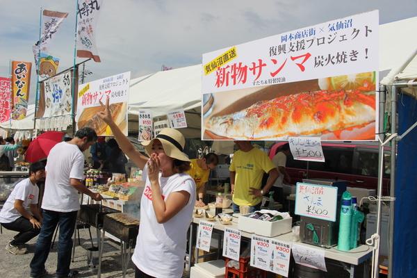 サンマの炭火焼の所で女性販売の方が宣伝している写真