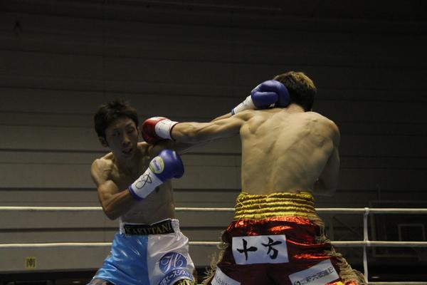 角谷 淳志選手と相手選手の互いが左ストレートパンチをしている写真
