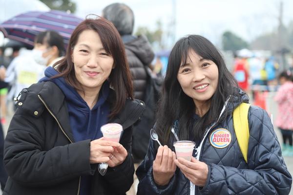 デザートとスプーンを手に笑顔で写っている2名の女性の写真