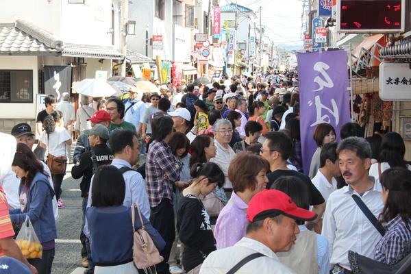 秋晴れの下、篠山味まつりの商店街で道を埋め尽くす沢山の人で賑わう様子の写真
