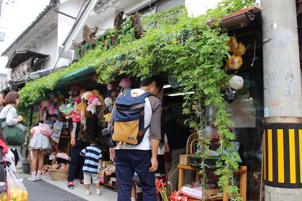 街の駄菓子屋さんで大人も子供もお菓子を見ている写真