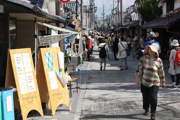 ササヤマルシェ会場（河原町）の看板を見ている女性客の写真