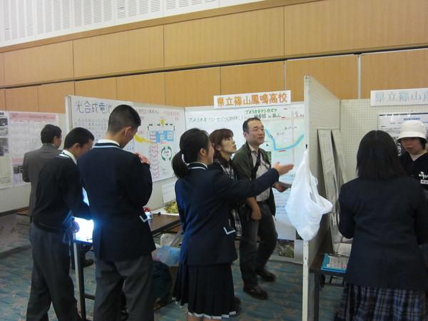 高校別に作られた発表のブースが設けられており、来場者が興味深く発表内容を見ている様子の写真
