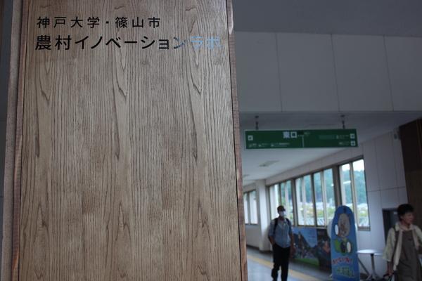 縦長の木の板に神戸大学・篠山市 農村イノベーションラボと書かれている写真