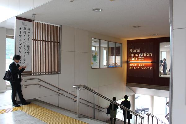 階段の途中の頭上にある壁にイノベーションラボと書かれた広告が載っている写真