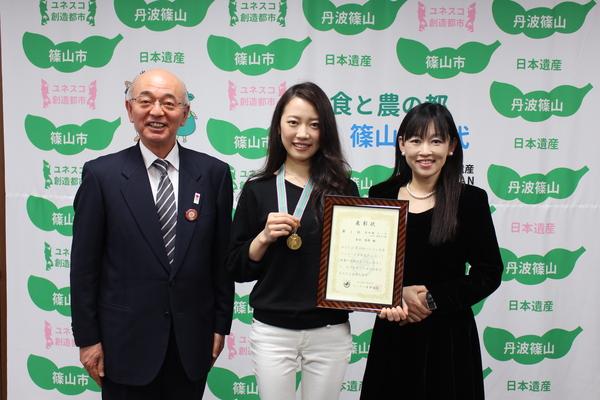 メダルと賞状を手に持っている吉田さん・ピアノの先生中村 貴子さん・市長との記念写真