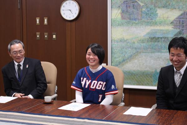 篠山中学校2年の戸倉 紗季さん、先生方が机に座り市長に笑顔で報告している写真