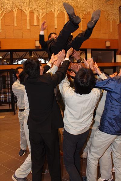 男性を胴上げしている写真