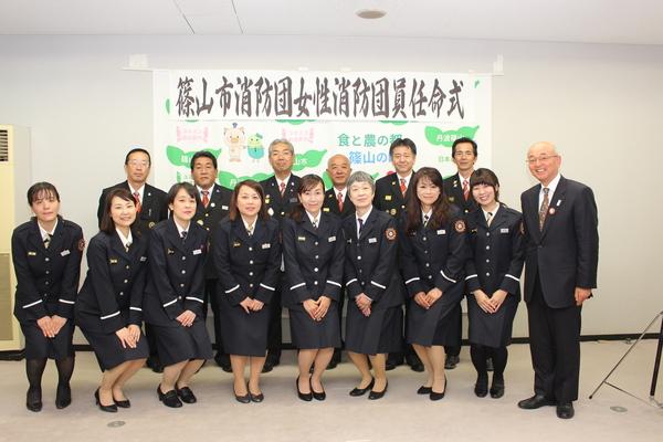 前列に、市長と制服を着た女性消防団8名、後列に6名の男性が立っている写真