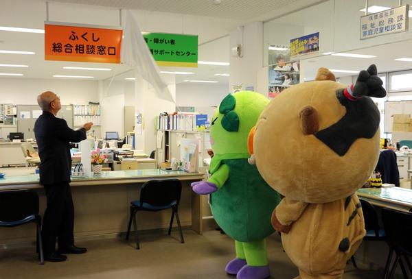 「高齢者・障がい者権利擁護サポートセンター」が開設され、部署の表札を市長とゆるキャラ「まめりん」で除幕している写真