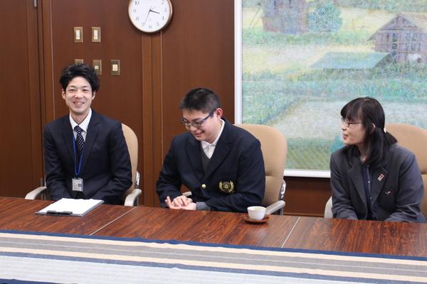 篠山養護学校高等部3年の堂東 直矢さんが笑顔でお話しして、両端には男性と女性が座っている写真