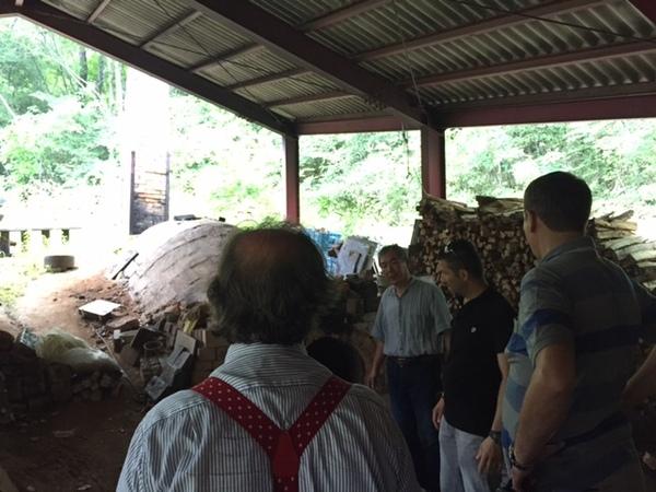 窯の前で窯元の男性と外国人の方3名が立っている写真