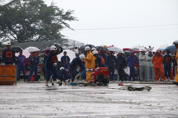 団員の方同士ホースを出していて周りでは沢山の方がその様子を見ている写真