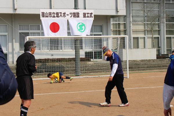 ゴールキーパーが市長の蹴ったボールを掴んでおり、市長が残念そうに頭を右手で押さえている様子の写真