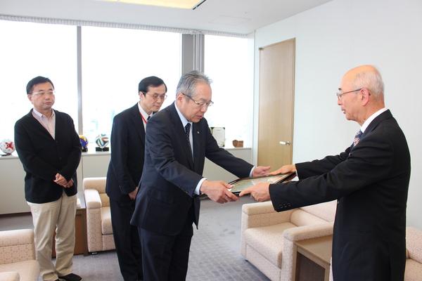 高梨さんが市長から額に入った感謝状を受け取っており、その後ろに大国さんと長沼さんが受領されている様子を見ている写真