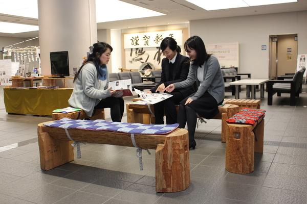 ベンチに女性3人が座って談笑している写真