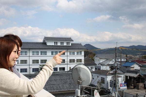 市長室のバルコニーから、指をさしている女性の写真