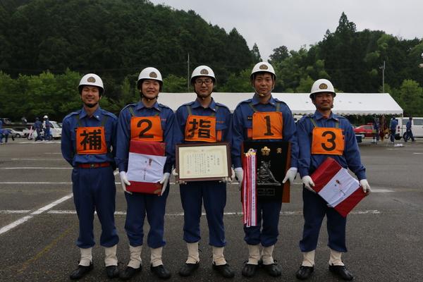 優勝チーム4名の団員の方が笑顔で記念撮影写真