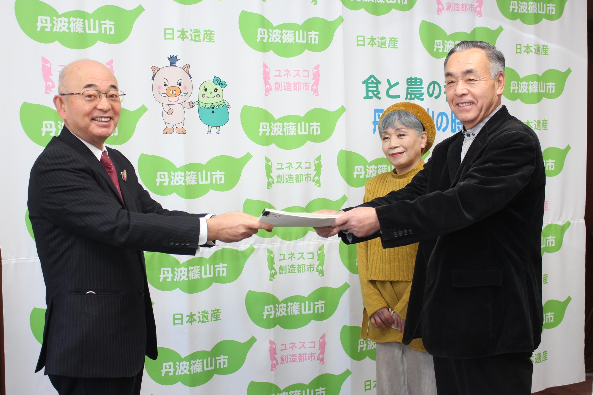 審議会委員2名が、市長に答申書を手渡ししている