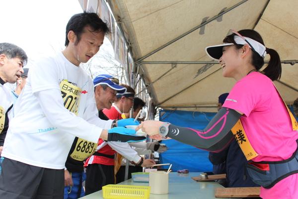 マラソンの途中、テントの中で食べ物が用意されて受け取っている写真