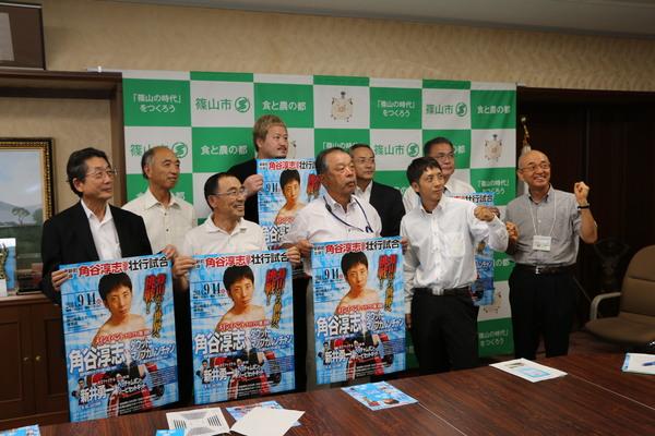 角谷淳志（かくたにあつし）選手、関係者、市長らがガッツポーズをしたり、手にポスターを持って笑顔で写っている写真