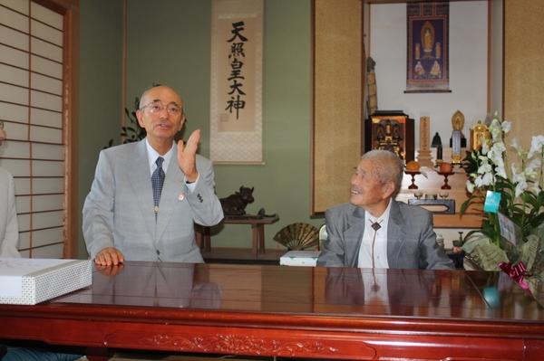 大西 太一郎さんのご自宅で市長が話をしているのを笑顔で大西さんが見ている様子の写真