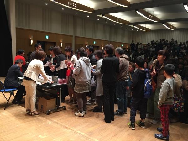 壇上に清水さんが座っており、サインを求めて長蛇の列が出来ている様子の写真