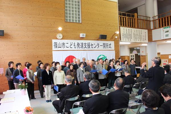 多くの年配の方が合唱している写真