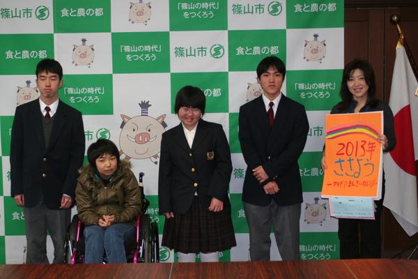 笹用カレンダーを持ち立っている女性と篠山養護学校の生徒4名で記念撮影をしている写真