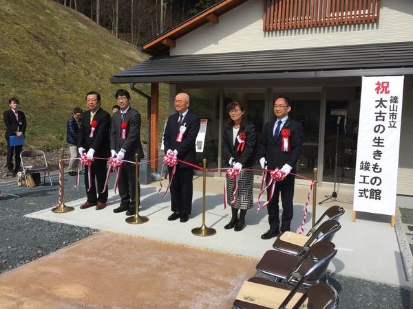 「篠山市立太古の生きもの館」竣工式で建物の前で市長らがテープカットしている写真