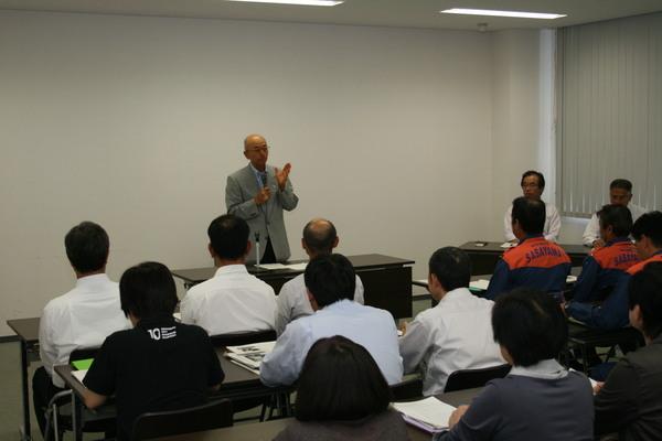 関係者が座っている前で市長がマイクを持って話をしている写真