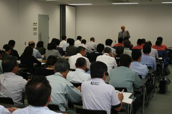 座って市長の話を聞いている関係者たちの後姿を映した写真