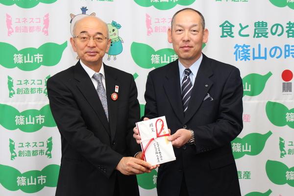 社長の降矢 寿民さんと市長がお祝い袋を一緒に手に持ち記念写真