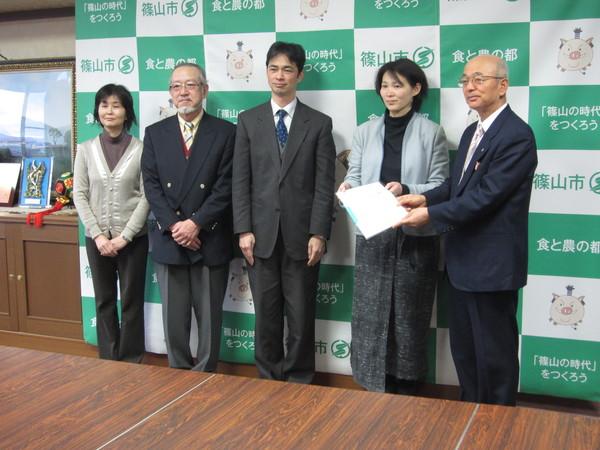 市長が代表の方と提言書を一緒に持ち、エネルギー部会の方々と一緒に記念撮影写真