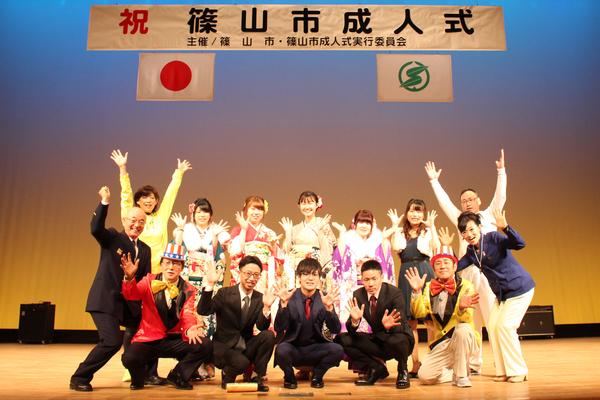 舞台上で、市長と市長劇団の出演者、実行委員の新成人の大見君、井谷君、振袖を着た4名新成人が一緒に写っている集合写真