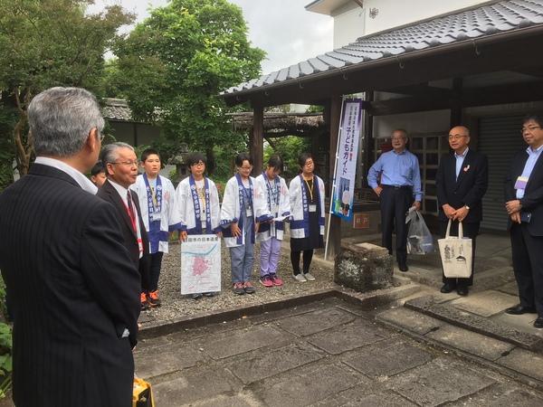 伝統的建造物群保存地区協議会に参加している男性が話しているのを市長や法被姿の子供らが聞いている写真