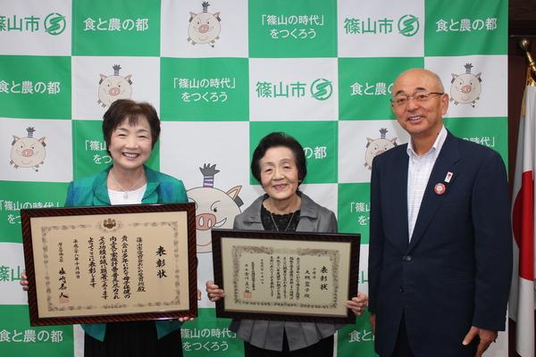 「厚生労働大臣表彰」おかの愛育班 畑さん・「母子保健功労者表彰」大槻蓉子さんが表彰状を持って市長と一緒に記念撮影