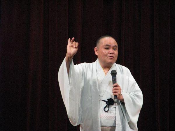 講師の三遊亭 多歌介さんが舞台の上で1人で話をされている写真