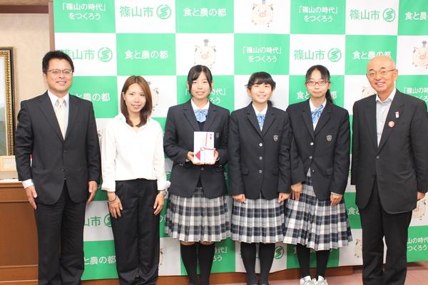 市長と関係者と女子生徒3名で記念撮影している写真