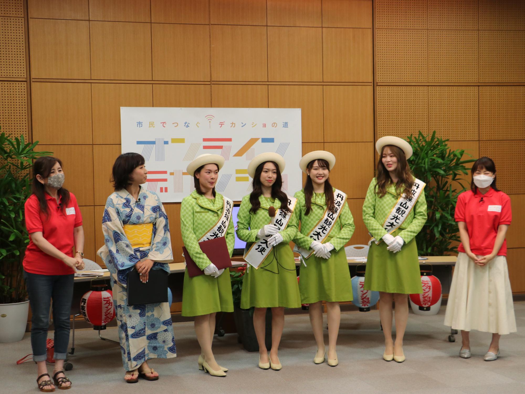 オンラインデカンショ配信の特設スタジオで観光大使の任命式を行っている。新しく任命された第10代観光大使と第9代観光大使、司会者2名、観光協会職員が並んでいる。