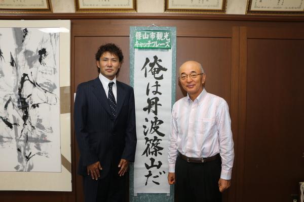 半紙に書かれた「俺は丹波篠山だ」のキャッチフレーズを挟んで廣長 優志さんと市長が映っている写真