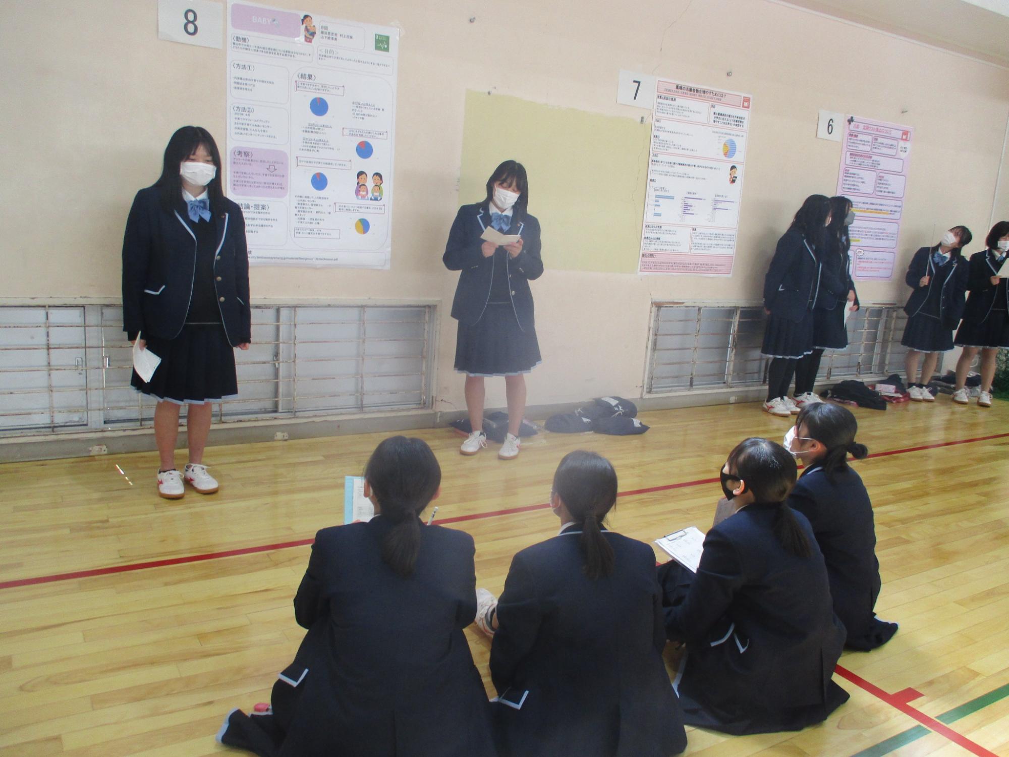 壁に張った研究成果を高校生たちが発表している